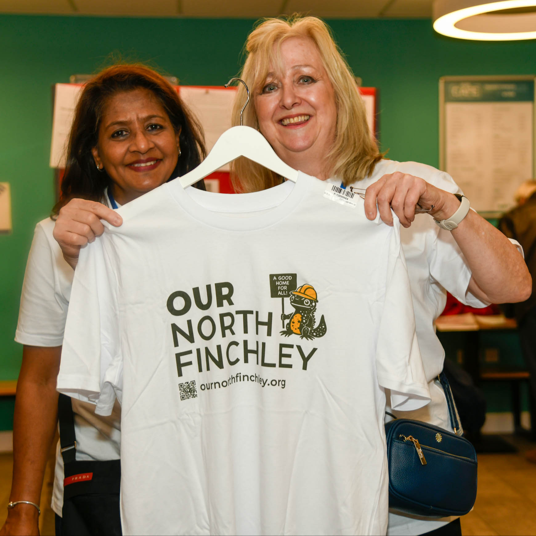 Supporters holding an Our North Finchley t-shirt
